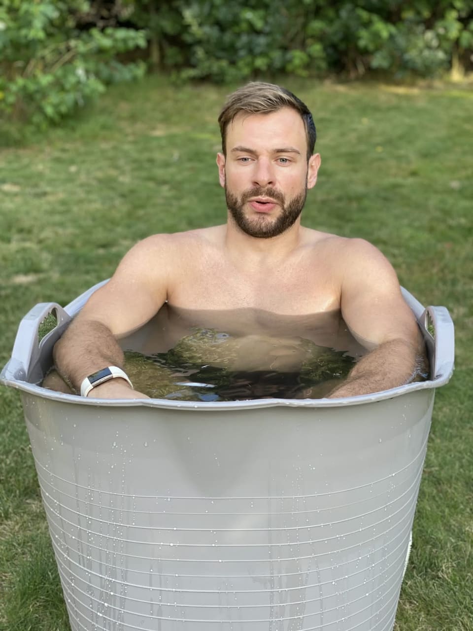 Jorn van Vrijaldenhoven in het ijsbad, in een kuip met koud water op een grasveld